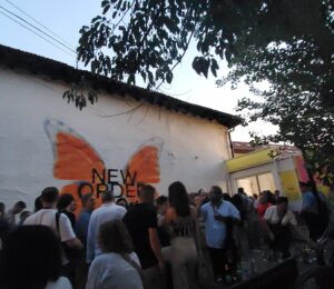 Dokufest attendees enter the Lumbardhi Bahce in Prizren for the festival’s opening, passing a mural of a butterfly with the festival slogan ‘New Order’. Photo: BIRN