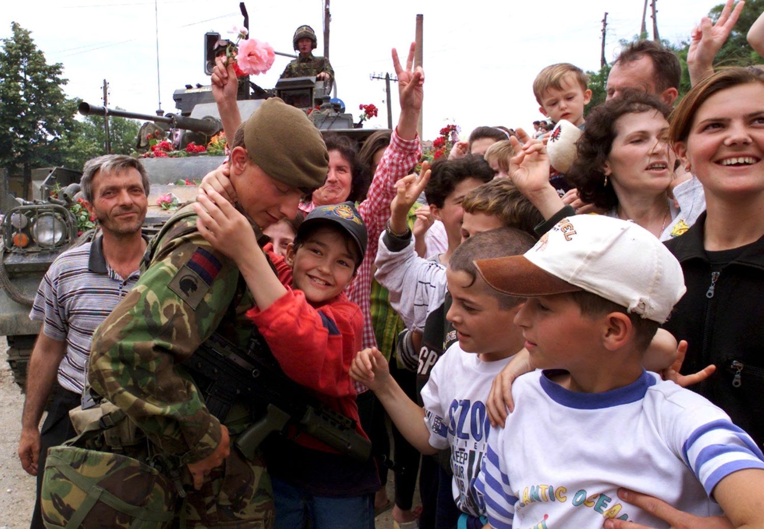 An ethnic Albanian boy hugs a British NATO soldier as hundreds of Albanians celebrate the arrival of NATO troops in Pristina on Sunday 13 June 1999. Photo: EPA/Anja Niedringhaus