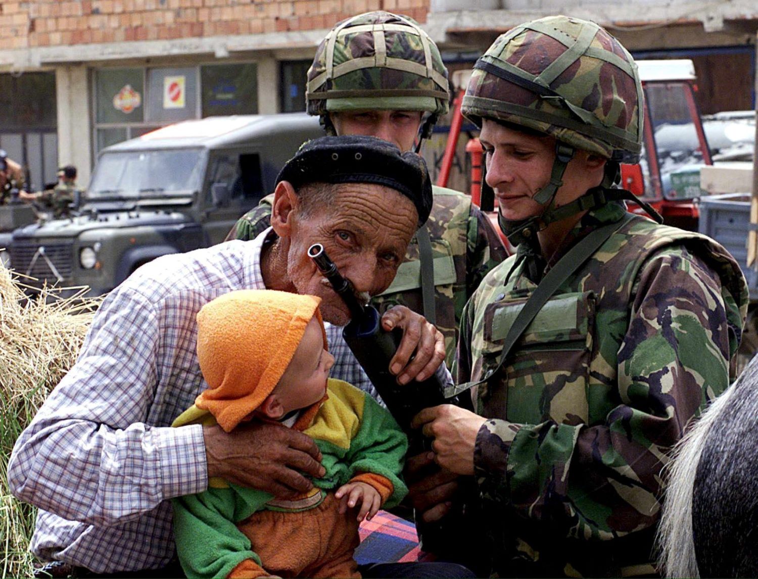 A grateful Kosovar shows his appreciation to British NATO soldier with the peacepeeping force in Kosovo, KFOR, Simon Shiel (R) by kissing his SA 80 rifle in Urosevac, some 20km south of Pristina, on Monday 14 June 1999. The old man and his 10 month old grandson were stopped by Simon's Warrior Armoured Fighting Vehicle on his return from exile in a Maceonian Refugee Camp to the Kosovo. He now felt safe under the protection offered by the British forces and started his long journey home by horse and cart with his entire belongings with him, along with hay to feed the horse. (UK OUT) EPA PHOTO PA-Crown Copyright/Kevin CAPON