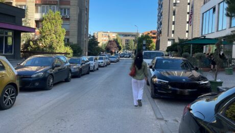 Pedestrian walking on the road due to cars parked on the pavement in the 'Aktash' neighbourhood in Prishtina. Photo: BIRN